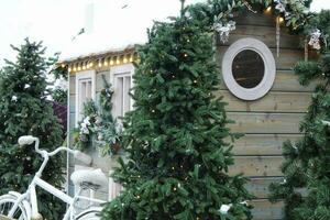 Christmas porch decoration idea. House entrance and window sill decorated for holidays. New year winter front yard festive snow tree garlands on facade photo