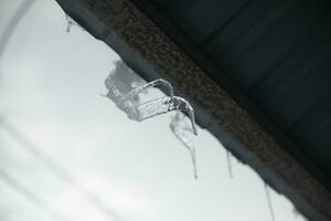 Ice on goat of roof. Icicles on roof. Ice on house. photo