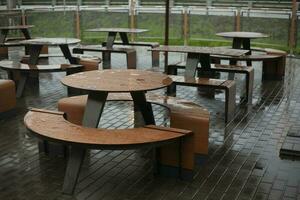 Tables of street restaurant. Rain in city. photo