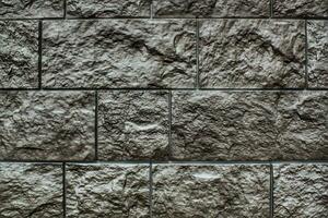 Decorative granite cobble stone tile brick wall texture background. Seamless pattern backdrop. Crafted modern brickwork outer wall. House exterior with sandstone blocks tiled photo