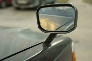 Rear view mirror. Mirror on car is mounted on hood. Overview for driver. photo