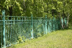 Green fence in park. Steel fence. Private territory. photo