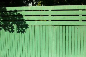 Wooden fence. Green board. Fencing in rural areas. photo