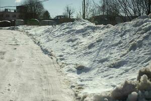 Snow on road. Melted snow on rural road. Winter weather details. photo