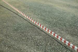 Red tape over asphalt. Tape over road. Fence of territory. photo