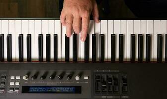 manos masculinas practicando en el teclado del piano electrónico. foto
