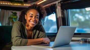 Happy African American Young Adult Female Enjoying Working Remotely Inside Her RV Camper Trailer - . photo