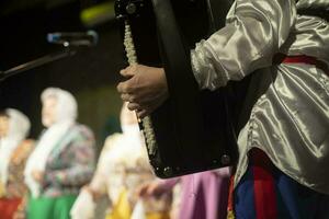 Playing folk instrument. Folklore ensemble. Accardion in hand. photo