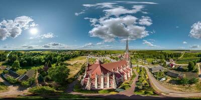 full hdri 360 panorama aerial view on red brick neo gothic or baroque catholic church in countryside or village in equirectangular projection with zenith and nadir. VR  AR content photo
