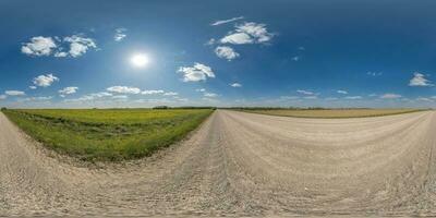 360 hdri panorama on gravel road near farming field with clouds on blue sky in equirectangular spherical  seamless projection, use as sky replacement in drone panoramas, game development skydome photo