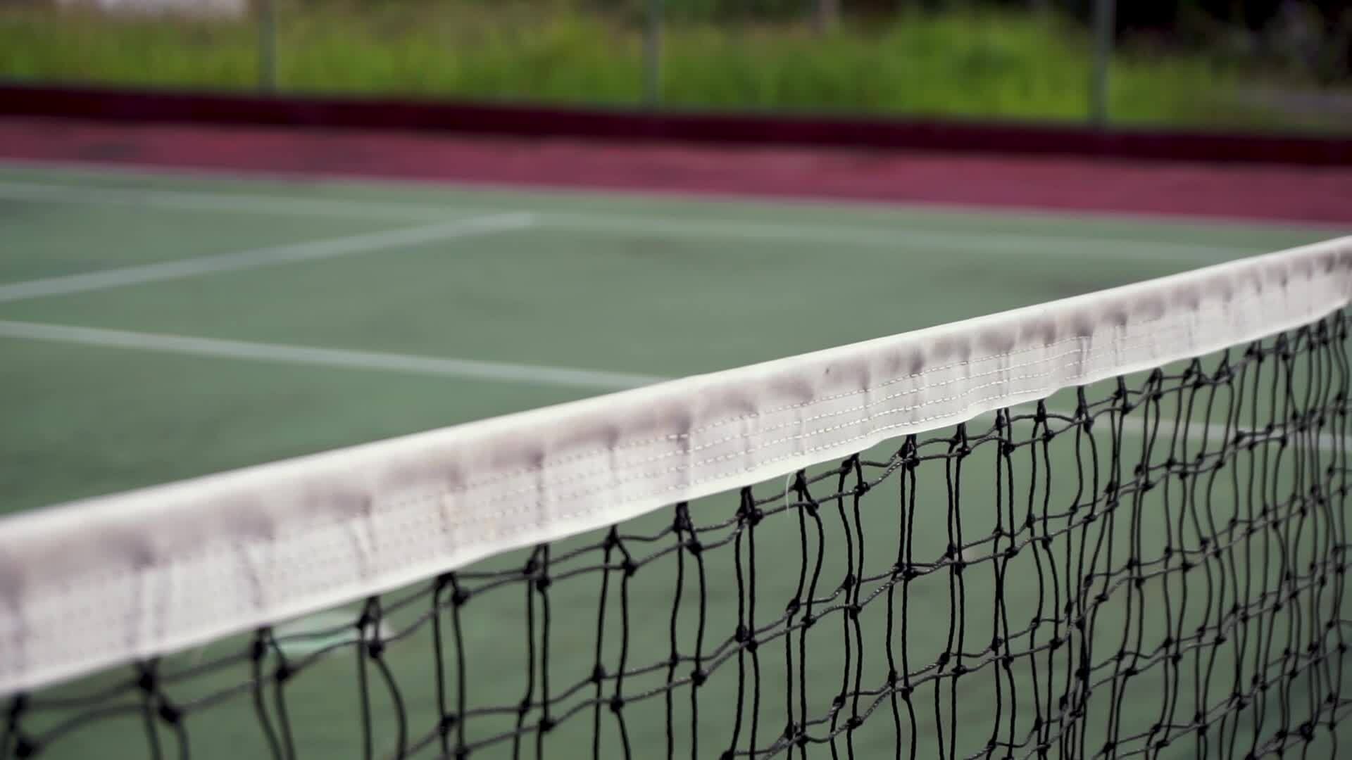 Tennis ball clips the top of the net. Slow motion. Tennis ball hit the