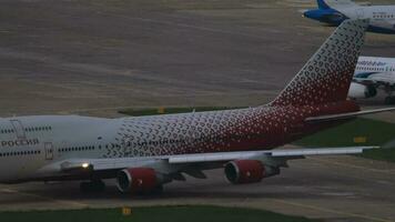 sochi, Rússia Julho 29, 2022 - boeing 747 do rossiya taxiando em a pista às sochi aeroporto. jumbo jato em a aeródromo. brilho do a Sol brilho em borda a avião video