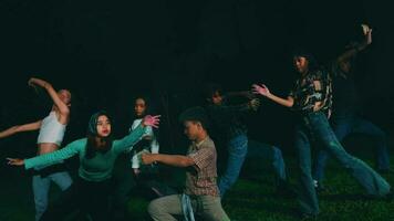 a group of Asian teenagers playing and dancing together in the dark of night video