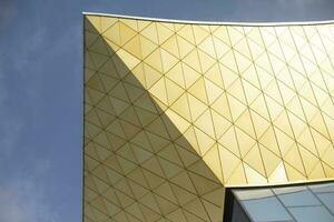 Modern building made of glass and metal. Golden color in architecture of building. Modern style of building. photo