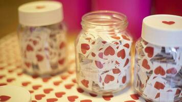 Hearts in jars. Stickers made at home. Lot of red hearts in glass jars. White caps. photo