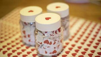 Hearts in jars. Stickers made at home. Lot of red hearts in glass jars. White caps. photo