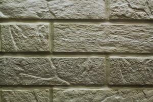 Decorative granite cobble stone tile brick wall texture background. Seamless pattern backdrop. Crafted modern brickwork outer wall. House exterior with sandstone blocks tiled photo