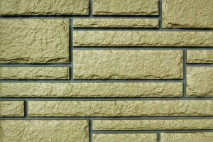 Decorative granite cobble stone tile brick wall texture background. Seamless pattern backdrop. Crafted modern brickwork outer wall. House exterior with sandstone blocks tiled photo