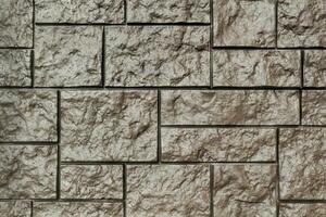 Decorative granite cobble stone tile brick wall texture background. Seamless pattern backdrop. Crafted modern brickwork outer wall. House exterior with sandstone blocks tiled photo