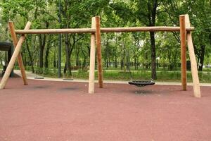 Wooden playground made of natural eco-friendly material in public city park. Modern safety children outdoor equipment. Concept of sustainable lifestyle and ecology. Children rest and games on open air photo
