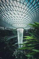 el lluvia vórtice, cuales el joya llamadas otro realce de Singapur Changi aeropuerto, es el mas grande y más alto interior cascada en el mundo a 130 pies alto. foto