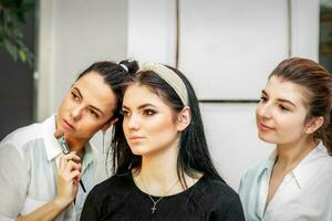 maquillaje artista haciendo maquillaje para joven hermosa novia aplicando Boda maquillaje en un belleza salón. foto