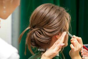 estilista y maquillaje artista preparando novia antes de el Boda en un belleza salón. foto