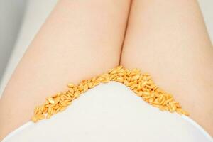 Sugaring concept. Wax granules lying in a row on female bikini area close up. photo