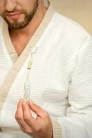 Young caucasian man receiving nasal inhalation Maholda with essential oil in the nose at a hospital. photo