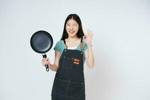 Restaurant owner sme woman showing OK sign and holding pan isolated on white background. photo