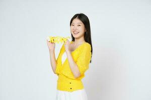 Smiling woman holding yellow glasses isolated over white background. photo