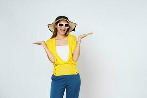 Young woman wearing a sun hat and sunglasses, presenting or showing open hand palm with copy space for product isolated on white background. photo