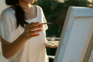 la artista femenina profesional usa pincel en el arte abstracto para crear una obra maestra. pintura de pintor con acuarelas o aceite en casa de estudio. bella mujer disfruta pintando como hobby. recreación laboral foto