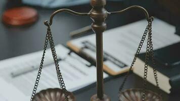 Business and lawyers discussing contract papers with brass scale on desk in office. Law, legal services, advice, justice and law concept picture with film grain effect video