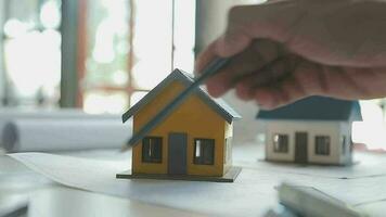 equipe do multiétnico arquitetos trabalhando em construção planos dentro encontro sala. engenheiros discutindo em projeto dentro escritório. maduro homem de negocios e mulher em pé por aí mesa trabalhando em projeto. video