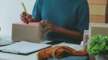 startende kleine bedrijven mkb-eigenaren vrouwelijke ondernemers controleren online bestellingen om zich voor te bereiden op het inpakken van de dozen, verkopen aan klanten, mkb-bedrijfsideeën online. video