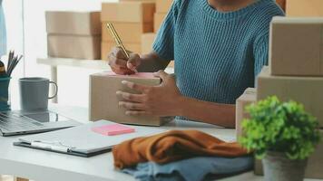 startende kleine bedrijven mkb-eigenaren vrouwelijke ondernemers controleren online bestellingen om zich voor te bereiden op het inpakken van de dozen, verkopen aan klanten, mkb-bedrijfsideeën online. video