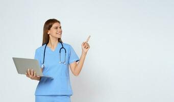 retrato de sonriente joven mujer médico con estetoscopio participación ordenador portátil y señalando con mano en Copiar espacio aislado en blanco antecedentes. foto