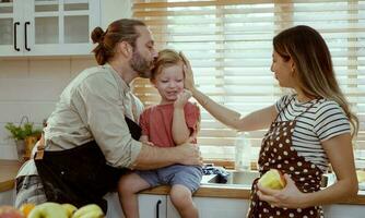 Happy family eating fruits in the kitchen. photo