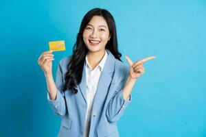 retrato de joven asiático mujer de negocios posando en azul antecedentes foto
