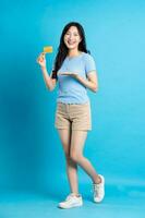 full body image of beautiful asian girl posing on blue background photo