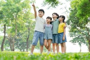 grupo de linda asiático niños teniendo divertido en el parque foto