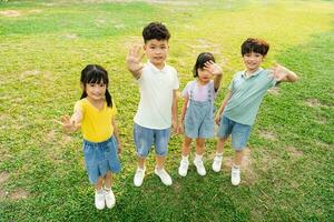 grupo de linda asiático niños teniendo divertido en el parque foto