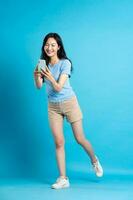 full body image of beautiful asian girl posing on blue background photo