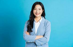 portrait of asian business woman posing on blue background photo