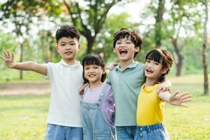 grupo de linda asiático niños teniendo divertido en el parque foto