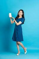 Portrait of beautiful woman in blue dress, isolated on blue background photo