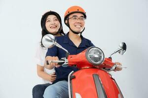 A couple wearing helmets and riding a motorbike photo