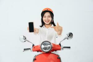 a woman wearing a helmet and driving a motorcycle photo