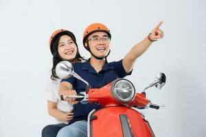 A couple wearing helmets and riding a motorbike photo